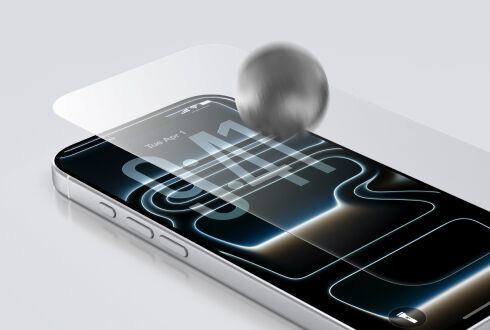 Close-up of a smartphone with a transparent screen protector, showing a metal ball impacting the screen to demonstrate durability and impact resistance. Close-up of a smartphone with a transparent screen protector, showing a metal ball impacting the screen to demonstrate durability and impact resistance.