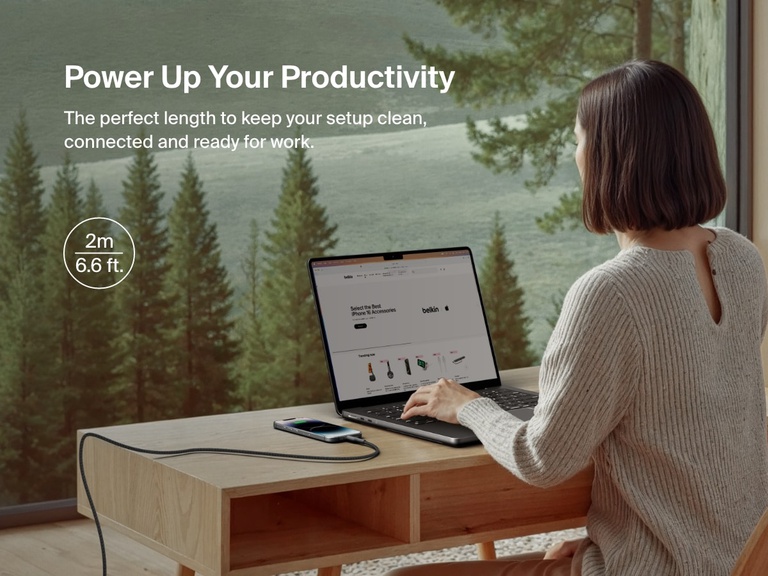 Belkin BoostCharge Pro USB-C Braided Cable with Lightning Connector in a 2m (6.6 ft.) length is shown powering an iPhone at a desk, offering extended reach and reliable charging for a productive workspace.