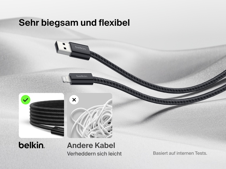 Ein Belkin BoostCharge USB A Kabel mit Lightning Connector wird auf einer weichen Stoffunterlage gezeigt, wodurch hervorgehoben wird, dass es mit seinem Kabelgeflecht extrem flexibel ist und sich nicht so leicht verheddert wie herkömmliche Kabel.