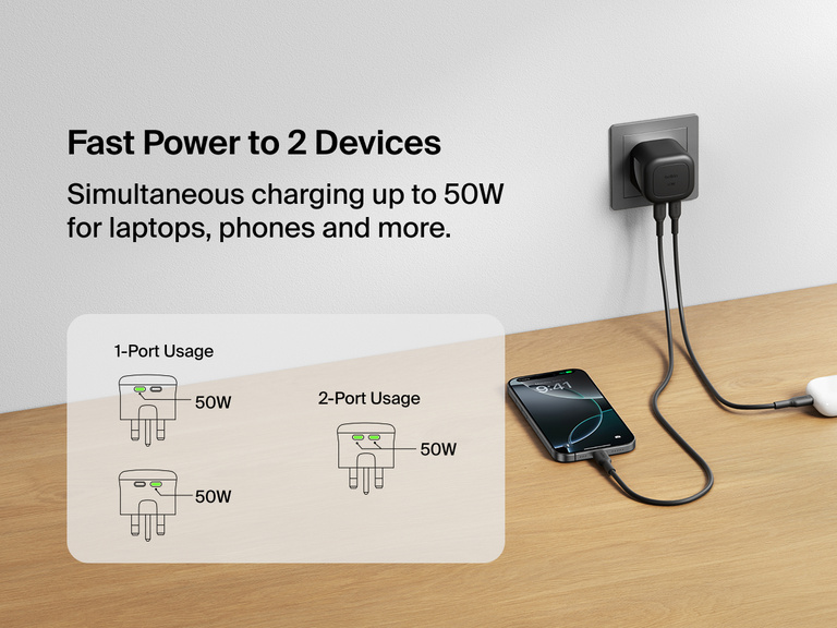 Belkin BoostCharge Pro Dual USB-C GaN Wall Charger 50W plugged into a wall outlet charging a smartphone and wireless earbuds simultaneously with diagram showing fast power delivery for one or two devices.