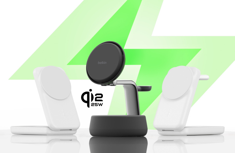 Three Belkin wireless charging stands on a reflective surface, two white models on the sides and a black model in the center, with a large green lightning bolt in the background and 'Qi2 25W' text beside the central charger. Three Belkin wireless charging stands on a reflective surface, two white models on the sides and a black model in the center, with a large green lightning bolt in the background and 'Qi2 25W' text beside the central charger.