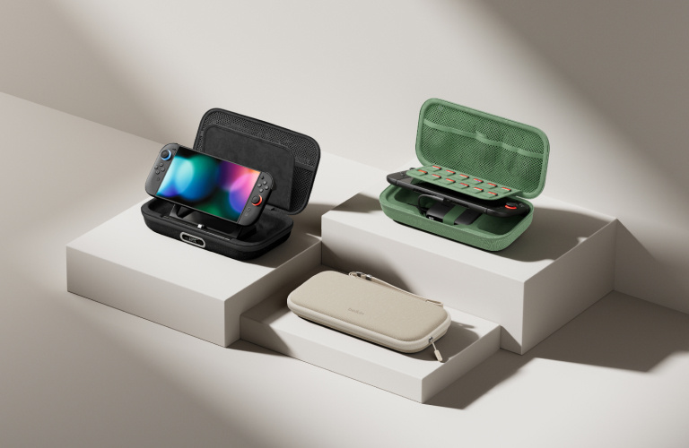 A minimalist display of portable gaming accessories, including handheld devices and protective cases, arranged on white pedestal blocks against a neutral background.