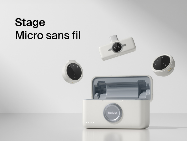 Image d'une paire de micros sans fil Belkin&nbsp;Stage avec deux pinces rondes et un &eacute;metteur rectangulaire flottant sur l'&eacute;tui de recharge des micros. Sur l'arri&egrave;re-plan gris, on peut lire &agrave; gauche &laquo;&nbsp;Micros sans fil Stage&nbsp;&raquo;.