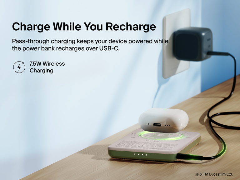 Belkin BoostCharge Slim Magnetic Power Bank 5K shown charging a smartphone on a table, highlighting its precharged battery ready for instant use out of the box.
