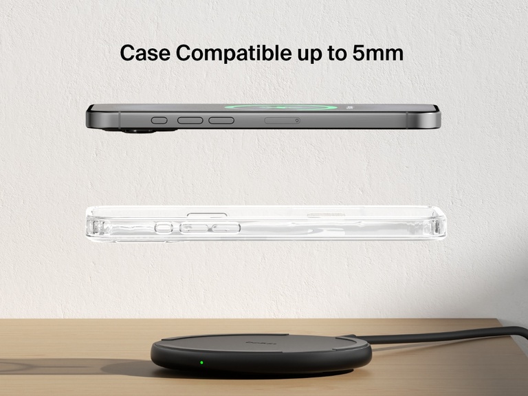 A black Belkin BoostCharge Wireless Charging Pad 15W is shown on a wooden surface with an iPhone and a transparent case floating above it, highlighting its compatibility with cases up to 5mm thick.