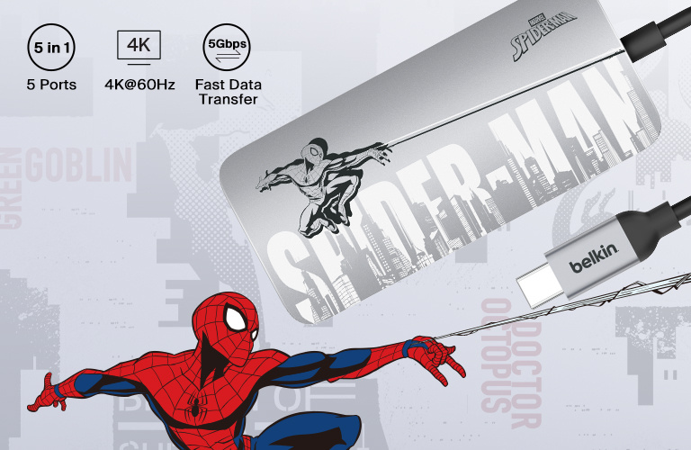 A sleek, silver Belkin Connect USB-C 5-in-1 Multiport Hub is connected to a laptop on a white desk, with SD cards nearby and a cup of coffee in the background, highlighting its portability and functionality.