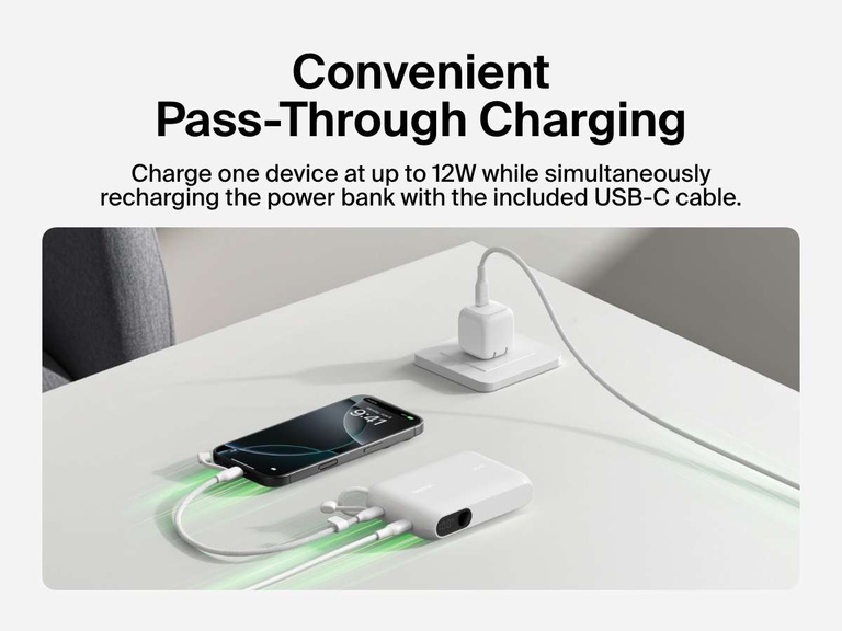 Belkin BoostCharge Power Bank 10K with Display shown delivering pass-through charging, powering a smartphone at up to 12W while recharging via the included USB-C cable.