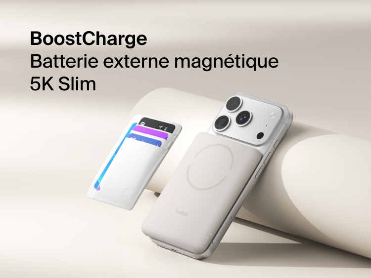 Belkin BoostCharge Slim Magnetic Power Bank 5K with Qi2 wirelessly attached to a smartphone, featuring a slim magnetic design with integrated card storage for portable on-the-go charging.