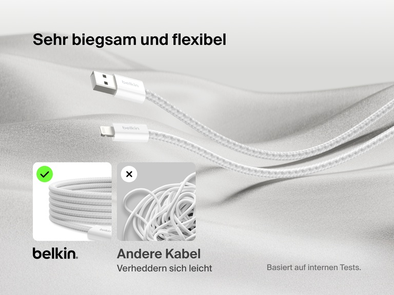 Ein Belkin BoostCharge USB A Kabel mit Lightning Connector wird auf einer weichen Stoffunterlage gezeigt, wodurch hervorgehoben wird, dass es mit seinem Kabelgeflecht extrem flexibel ist und sich nicht so leicht verheddert wie herkömmliche Kabel.