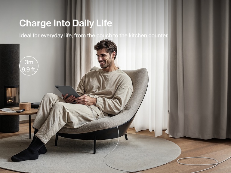 A man sits comfortably using a tablet connected to a 3-meter (9.9 ft) Belkin BoostCharge USB-A to USB-C Cable 15W, ideal for flexible, everyday charging from couch to counter.