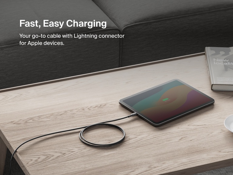 Belkin BoostCharge USB-C Cable with Lightning Connector shown charging an iPad on a coffee table, highlighting fast and easy charging for Apple devices.