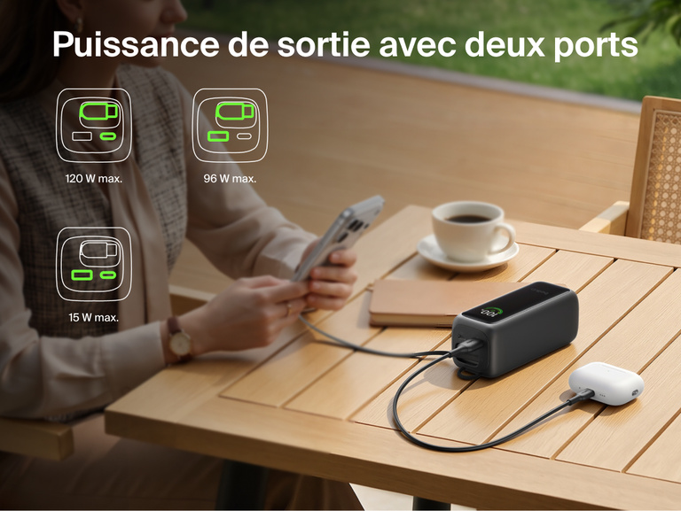 Image d'une batterie externe 22K UltraCharge avec c&acirc;ble r&eacute;tractable rechargeant un t&eacute;l&eacute;phone et un &eacute;tui d'&eacute;couteurs sur une table via deux&nbsp;ports, avec des ic&ocirc;nes indiquant les diff&eacute;rentes combinaisons de puissance disponibles.