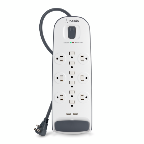 Belkin white surge protector power strip featuring twelve outlets in a circular and vertical layout, two USB-A ports at the bottom, a flat plug with a coiled black cord, and indicator lights for protection and grounding status near the power switch.