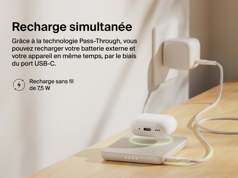 Belkin BoostCharge Slim Magnetic Power Bank 5K shown wirelessly charging earbuds while recharging via USB-C, demonstrating 7.5W pass-through charging functionality.