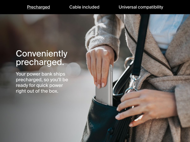 A woman places a silver Belkin BoostCharge Power Bank 10K into her handbag, highlighting its precharged convenience for immediate use right out of the box.