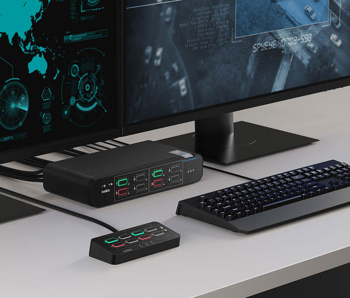 Close-up of dual monitors, a keyboard, and the Belkin Universal DisplayPort DuoClave Secure KVM Series with a control pad, enabling secure switching between multiple computer systems.