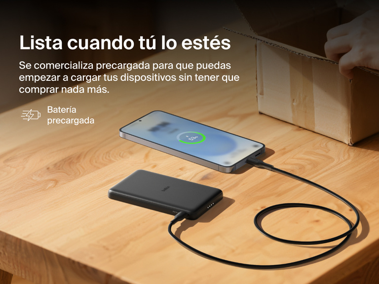 Belkin BoostCharge Slim Magnetic Power Bank 5K shown charging a smartphone on a table, highlighting its precharged battery ready for instant use out of the box.