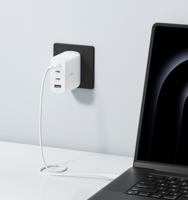 The BoostCharge Pro 4-Port GaN Wall Charger 112W is shown charging a MacBook Pro, highlighting a 0-50% charge in 38 minutes to boost productivity.