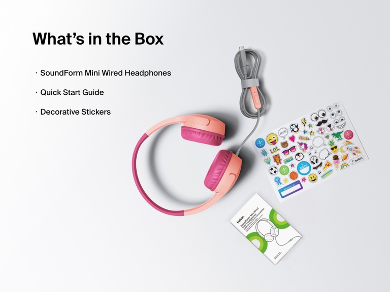 Flat lay image showing the contents of the Belkin SoundForm Mini Wired Headphones box, including the headphones, a quick start guide, and a sheet of decorative stickers.
