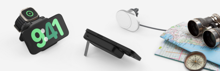 Travel-themed wireless charging bundle displayed with various charging accessories, including a phone stand with 9:41 displayed, an Apple Watch charger, and a car vent mount, accompanied by a map, compass, and binoculars on the side.