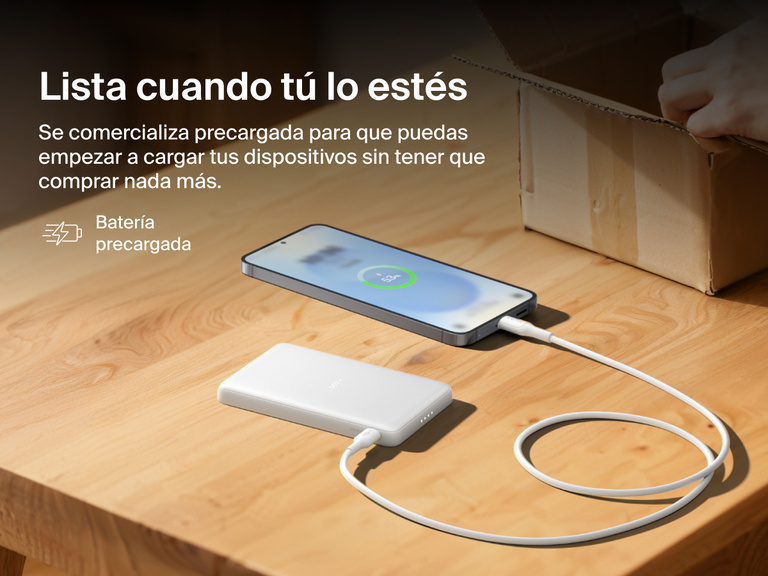 Belkin BoostCharge Slim Magnetic Power Bank 5K shown charging a smartphone on a table, highlighting its precharged battery ready for instant use out of the box.