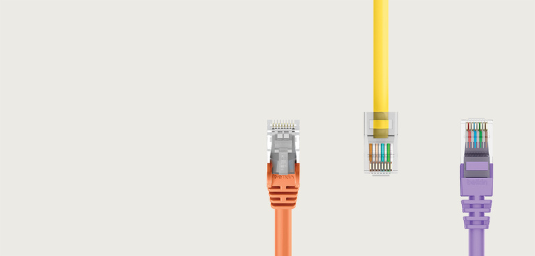 Three Ethernet cables with different colors—orange, yellow, and purple—displayed against a light beige background. The 'belkin' logo is positioned in the upper left corner. The cables are shown with their connectors facing forward, highlighting the internal wiring and transparent RJ45 connectors.