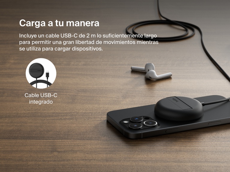 Se muestra una base magnética de carga inalámbrica con Qi2 de 15 W BoostCharge Pro de Belkin de color negro, sobre una superficie de madera y cargando un iPhone. También visible su cable USB-C de 2 m integrado que permite un emplazamiento flexible.