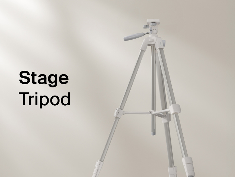 A minimalist product image showing a light gray tripod standing against a soft, neutral background. The text &ldquo;Stage Tripod&rdquo; appears on the left side of the image.