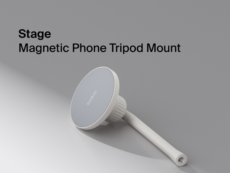 A close-up product image shows a Belkin Stage magnetic phone tripod mount with a smooth, circular magnetic surface and an adjustable stem. The mount rests on a softly lit gray background, with the text &ldquo;Stage Magnetic Phone Tripod Mount&rdquo; displayed on the left side.