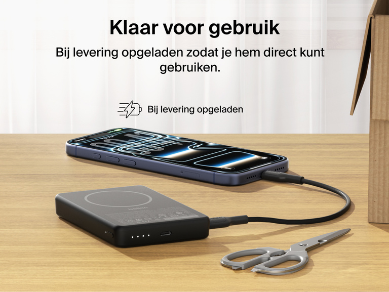Belkin BoostCharge Slim Magnetic Power Bank 10K precharged out of the box powering a smartphone via USB-C cable with portable battery placed on a desk