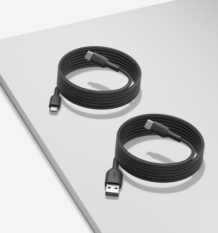 Two black Belkin braided cables, a USB-C to USB-A Cable 15W and a USB-C to USB-C Cable 60W, are coiled neatly on a light gray surface.