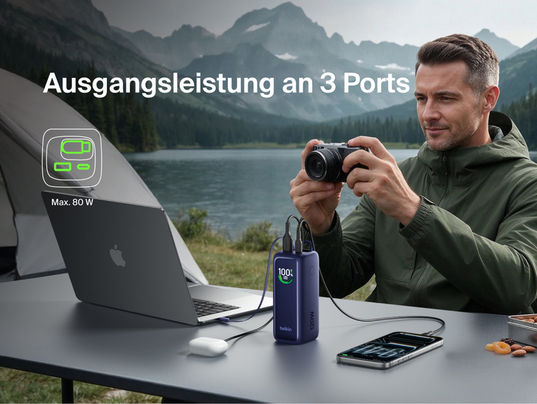 UltraCharge Powerbank 22K mit einziehbarem Kabel, die beim Camping im Freien gleichzeitig einen Laptop, eine Kamera und ein Smartphone l&auml;dt und dabei eine maximale Leistung von 80 W &uuml;ber drei Anschl&uuml;sse veranschaulicht.
