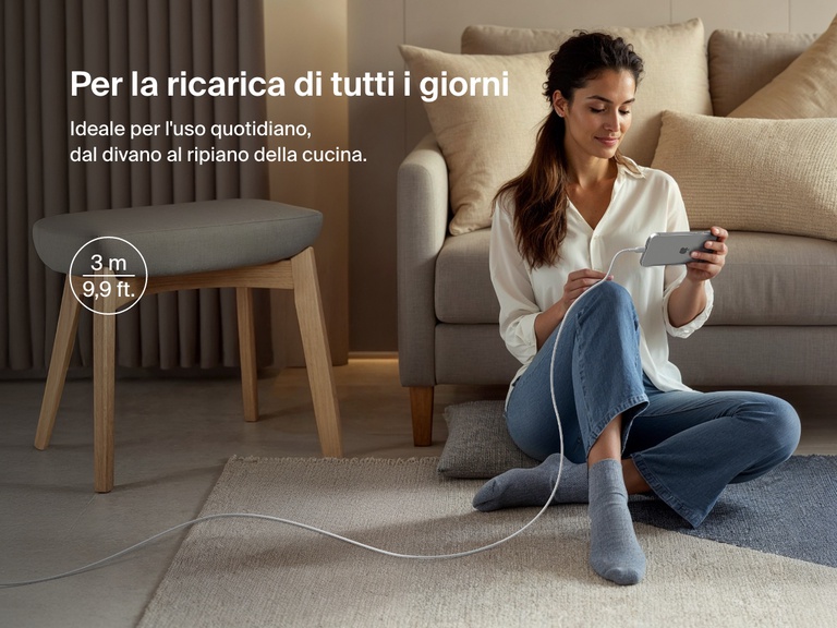 Woman sitting on the floor using a phone connected to the Belkin BoostCharge Pro USB-C to USB-C Braided Cable 240W, shown in a 3-meter (9.9 ft) length for everyday charging flexibility.