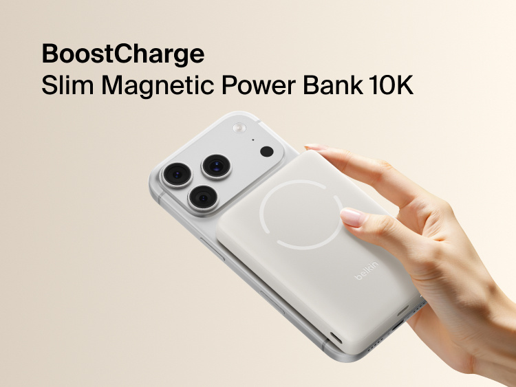 Belkin BoostCharge Slim Magnetic Power Bank 10K magnetically attached to iPhone showing slim portable design for wireless charging