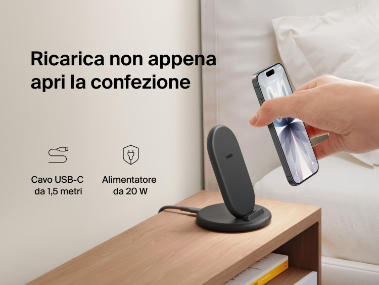 Belkin BoostCharge Wireless Charging Stand 15W shown on a bedside table with smartphone, includes 5ft USB-C cable and 20W power adapter for immediate charging out of the box.
