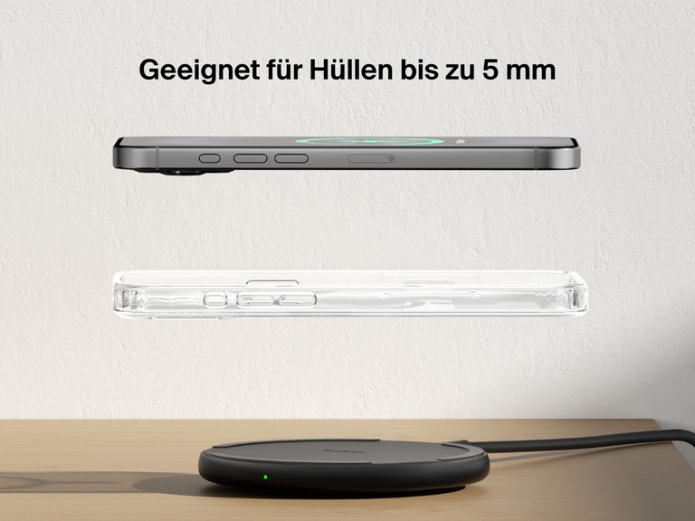 A black Belkin BoostCharge Wireless Charging Pad 15W is shown on a wooden surface with an iPhone and a transparent case floating above it, highlighting its compatibility with cases up to 5mm thick.