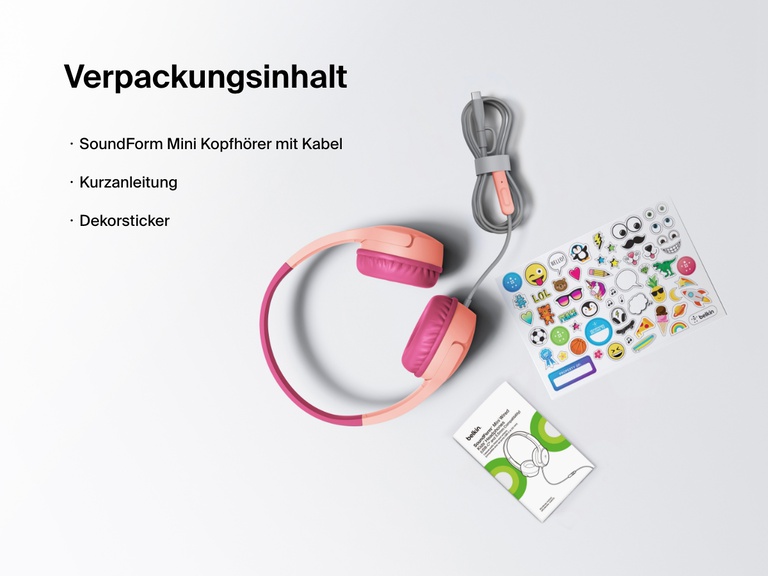 Flat lay image showing the contents of the Belkin SoundForm Mini Wired Headphones box, including the headphones, a quick start guide, and a sheet of decorative stickers.