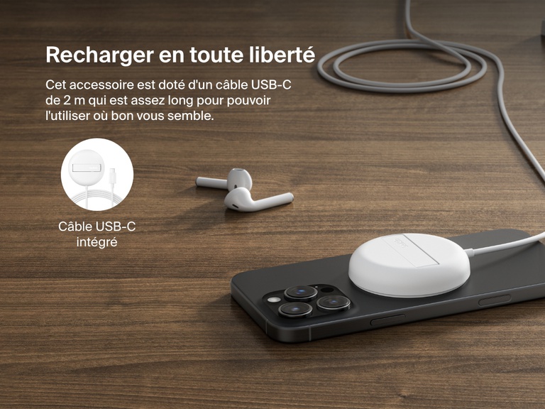 Image montrant la station de recharge sans fil blanche Belkin BoostCharge Pro avec Qi2 (15 W) posée sur un surface plane en bois, qui recharge un iPhone et qui met en avant son câble USB-C intégré (2 m).
