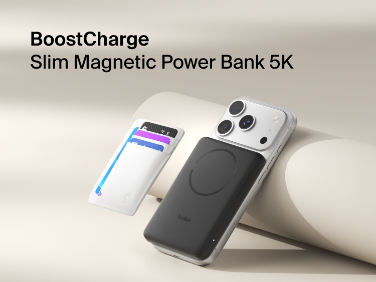 Belkin BoostCharge Slim Magnetic Power Bank 5K with Qi2 wirelessly attached to a smartphone, featuring a slim magnetic design with integrated card storage for portable on-the-go charging.