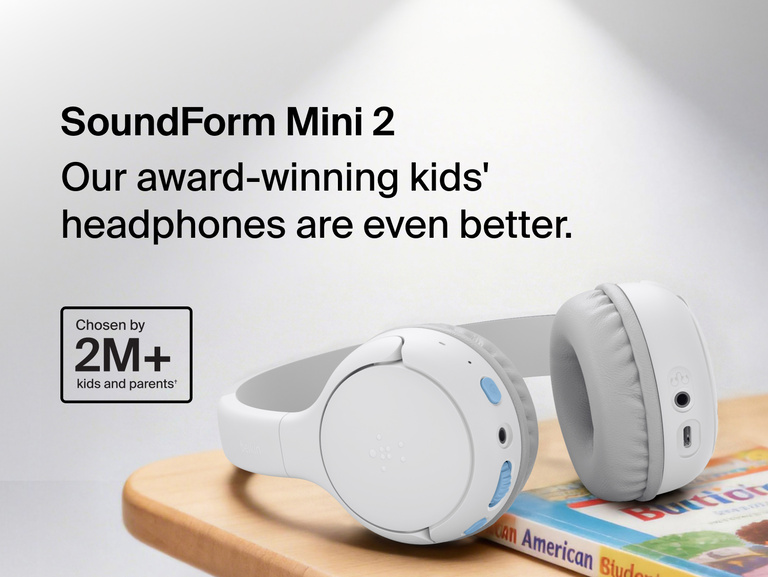 SoundForm Mini 2 Wireless On-Ear Headphones for Kids resting on a wooden surface beside a children's book, with on-image text reading Our award-winning kids' headphones are even better and Chosen by 2M+ kids and parents