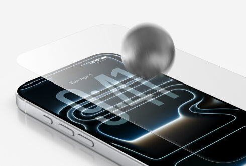 Close-up of a smartphone with a tempered glass screen protector being impact-tested by a metal ball. Close-up of a smartphone with a tempered glass screen protector being impact-tested by a metal ball.