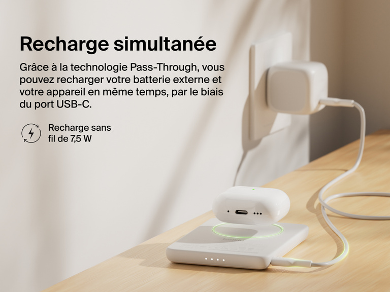 Belkin BoostCharge Slim Magnetic Power Bank 5K shown wirelessly charging earbuds while recharging via USB-C, demonstrating 7.5W pass-through charging functionality.