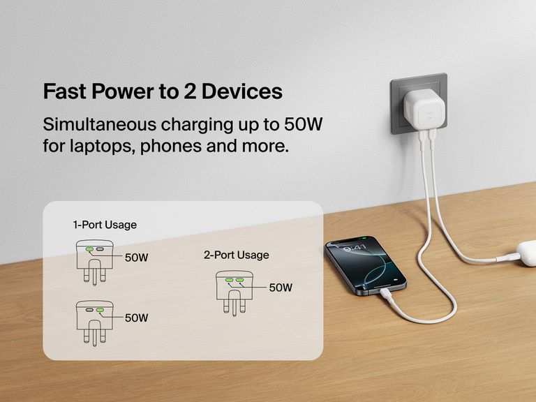 Belkin BoostCharge Pro Dual USB-C GaN Wall Charger 50W plugged into a wall outlet charging a smartphone and wireless earbuds simultaneously with diagram showing fast power delivery for one or two devices.