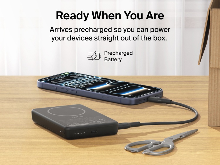 Belkin BoostCharge Slim Magnetic Power Bank 10K charging iPhone via USB-C on desk showing precharged battery ready for immediate use