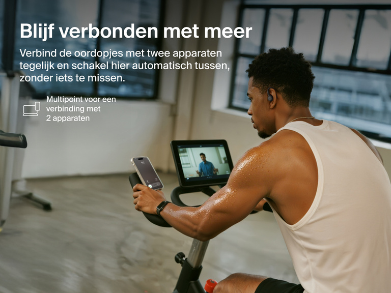 Belkin SoundForm ActiveFit Wireless Earbuds with multipoint 2-device connection, shown on a man using them while cycling on a stationary bike.