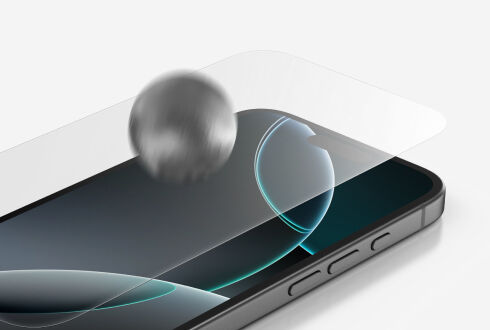 화면 보호용 강화유리가 부착된 스마트폰에 금속 공으로 충격 테스트를 하는 모습의 클로즈업 이미지.