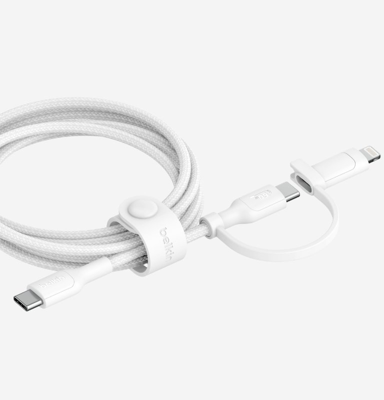 Un câble 2-en-1 BoostCharge Pro avec connecteurs USB-C et Lightning enroulé et rangé grâce à la sangle en silicone, sur fond noir.
