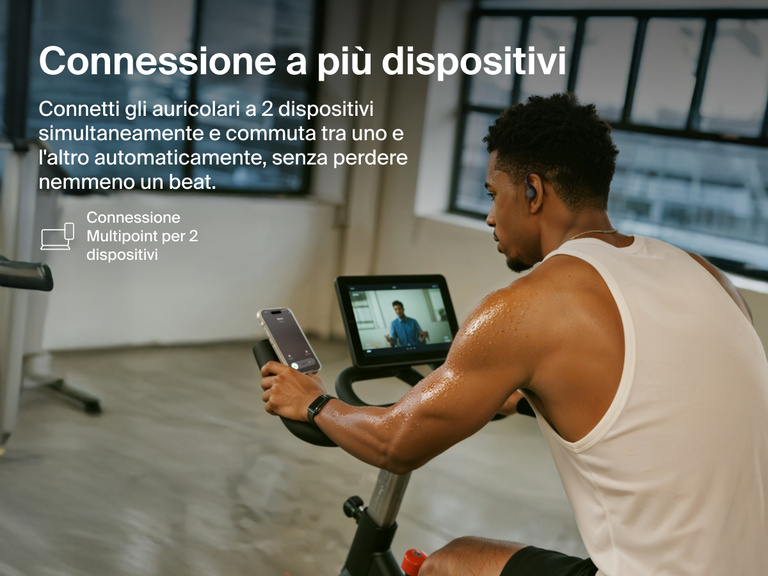 Belkin SoundForm ActiveFit Wireless Earbuds with multipoint 2-device connection, shown on a man using them while cycling on a stationary bike.