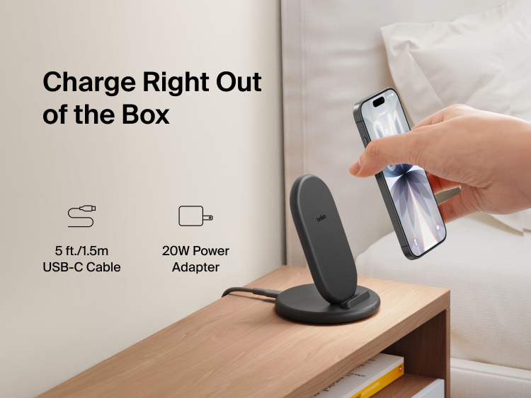 Belkin BoostCharge Wireless Charging Stand 15W shown on a bedside table with smartphone, includes 5ft USB-C cable and 20W power adapter for immediate charging out of the box.