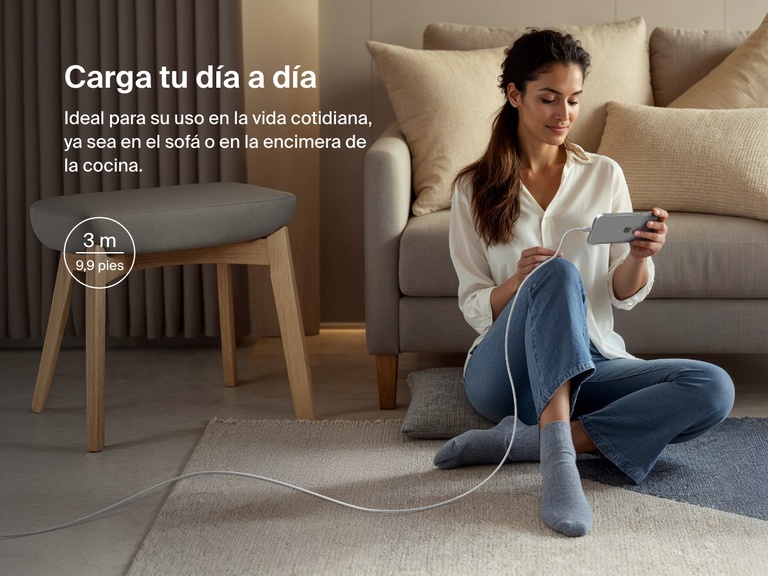 Woman sitting on the floor using a phone connected to the Belkin BoostCharge Pro USB-C to USB-C Braided Cable 240W, shown in a 3-meter (9.9 ft) length for everyday charging flexibility.
